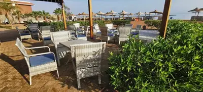 a group of chairs and tables and chairsitures at Modern 1BR Seaside Apartment C1 in Turtles Beach in Hurghada