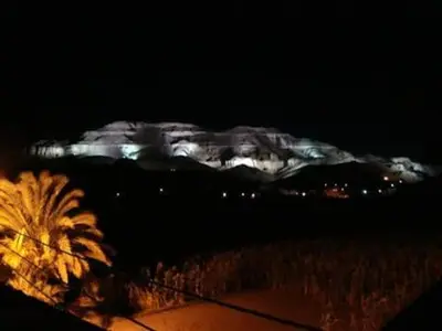 a view of a snow covered mountain at night at Desert studio in Al Aqālitah