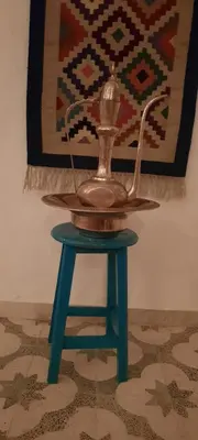 a tea pot on a stool with a rug at Desert studio in Al Aqālitah