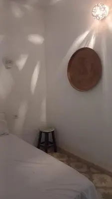 a bedroom with a bed and a light on the wall at Desert studio in Al Aqālitah