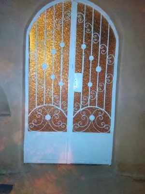 a door with an iron gate in a building at Desert studio in Al Aqālitah