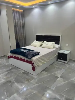 a bedroom with a large bed and a night stand at القيادات صف ثاني in Hurghada
