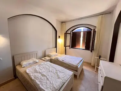 two beds in a room with a mirror at West Golf beautiful Townhouse in Hurghada