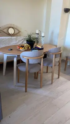 a dining room table with chairs and a wooden table with a plate of fruit at West Golf beautiful Townhouse in Hurghada