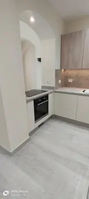 a kitchen with white cabinets and a black oven at West Golf beautiful Townhouse in Hurghada