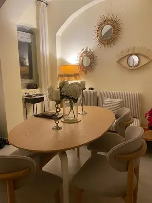 a dining room with a table and chairs and mirrors at West Golf beautiful Townhouse in Hurghada