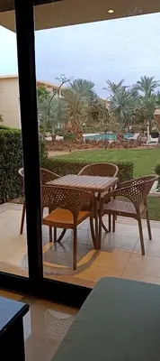 a table and chairs on a patio with a view of the ocean at Cozy studio G-cribs elgouna in Hurghada