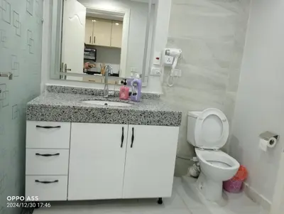 a bathroom with a toilet and a sink and a mirror at luxury one bedroom at scandic resort in Hurghada