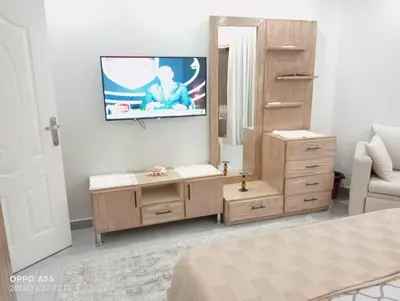 a bedroom with a dresser and a tv on the wall at luxury one bedroom at scandic resort in Hurghada