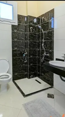 a bathroom with a shower with a toilet and a sink at 2 Karima house B in Al Aqālitah