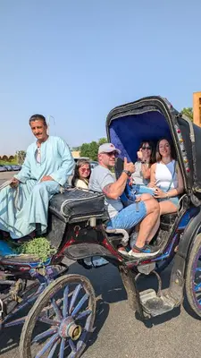 a group of people riding in a horse drawn carriage at 2 Karima house B in Al Aqālitah