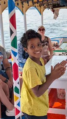 a young girl is smiling on a boat at 2 Karima house B in Al Aqālitah