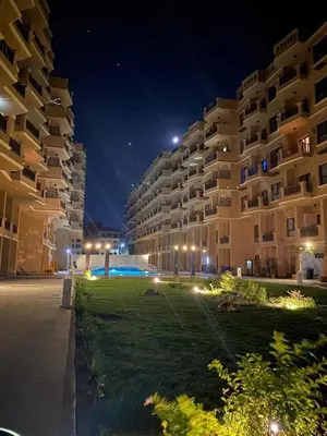 a large apartment building at night with a green lawn at Turtles beach resort in Hurghada