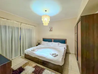 a bedroom with a large bed and a chandelier at Decoraive Appartment AlDaU Hurghada in Sahl Hasheesh