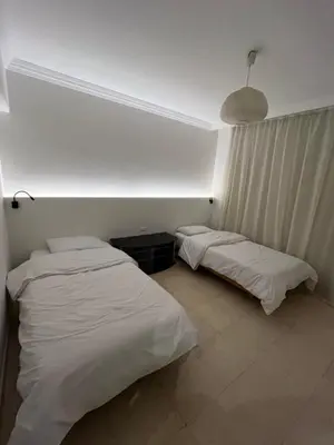 two beds in a room with white sheets at Sea front 2 bedrooms apartment in Esplanada in Hurghada