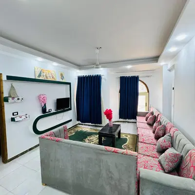 a living room with a couch and a tv at Many hahaha in Luxor