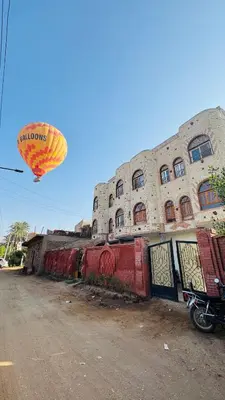 a kite flying in the sky over a building at Many hahaha in Luxor