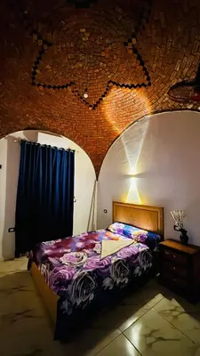 a bedroom with a bed and a brick wall at Many hahaha in Luxor
