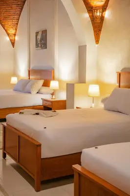 two beds in a room with two lamps on tables at opal legacy luxor in Luxor
