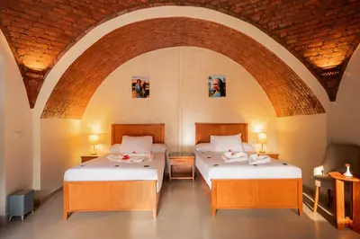 two beds in a room with an archway at opal legacy luxor in Luxor