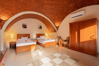 two beds in a room with a brick ceiling at opal legacy luxor in Luxor