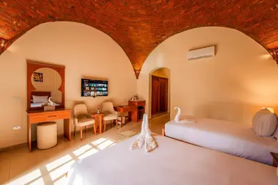 a bedroom with two beds and a desk and a room at opal legacy luxor in Luxor