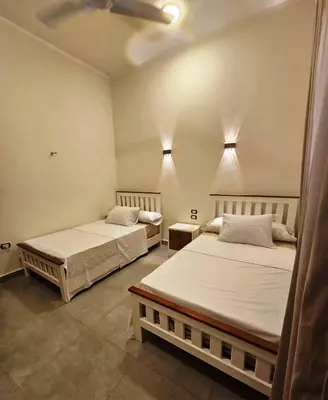 two beds sitting in a room with two at Malika House in Luxor