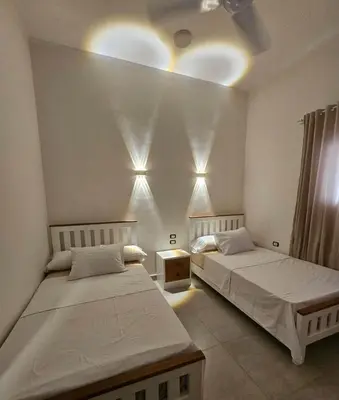 a bedroom with two beds and a ceiling with lights at Malika House in Luxor
