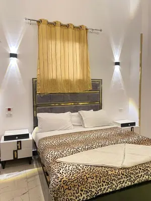 a bedroom with a bed and a window with lights at Alena guest house in Jazīrat al ‘Awwāmīyah