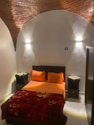 a bedroom with a bed with two orange pillows at الاقصر مركز القرنة مدينة القرنة الجديدة بجوار كافتيريا الميدان in ‘Ezbet Abu Ḥabashi