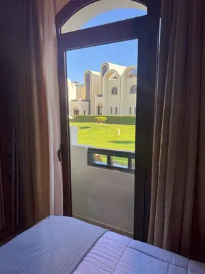 a bedroom door with a view of a building at Sahl Hasheesh Finest Chalet - Gravity resort beachfront family 2 bedroom - garden pools view waterpark NON EGYPTIAN ONLY in Hurghada