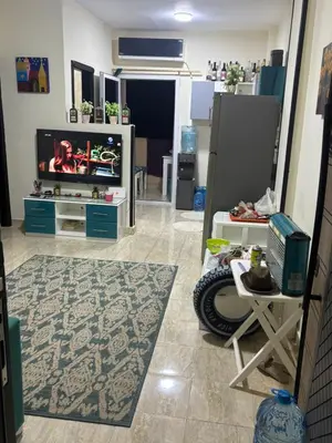 a living room with a flat screen tv and a table at El nour in Hurghada