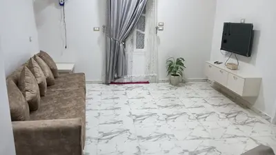 a living room with a couch and a tv at noreno guest house in Aswan