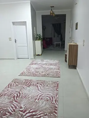 a hallway with two rugs on the floor in a room at noreno guest house in Aswan