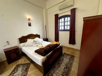 a bedroom with a bed and a window at Garden Level Oasis Near Nile in Luxor