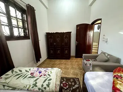 a living room with a bed and a couch at Garden Level Oasis Near Nile in Luxor