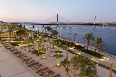 a view of a park with palm trees and a bridge at شركةستار للخدمات السياحيه in Aswān