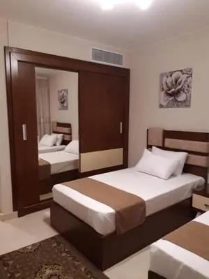 a bedroom with two beds and a mirror at Mangarove m3 1c 11 in Hurghada