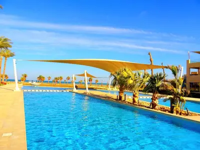 a swimming pool with palm trees and a canopy over it at Mangarove m3 1c 11 in Hurghada