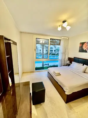 a bedroom with a bed and a large window at Mangarove m3 1c 11 in Hurghada
