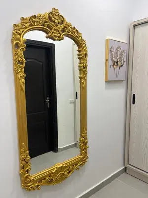 a gold mirror on a wall with a black door at Benashti Hurghada apartment in Hurghada