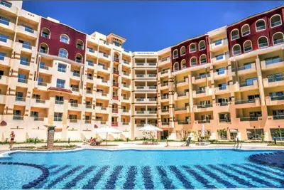 a large apartment building with a large swimming pool at Benashti Hurghada apartment in Hurghada