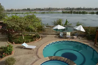 a swimming pool with a view of a river at House of Hathor in Luxor