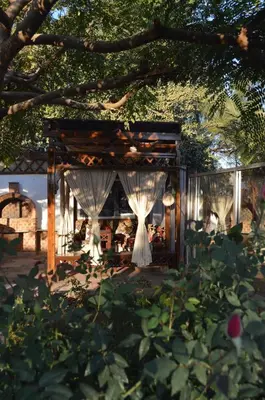 a pavilion with white drapes and a tree at House of Hathor in Luxor
