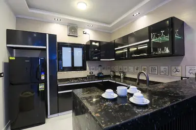 a kitchen with a black counter top and a refrigerator at Elbakry Hotel Luxor in Luxor