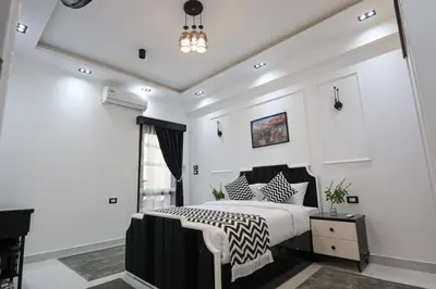 a bedroom with a black and white bed and a chandelier at Elbakry Hotel Luxor in Luxor