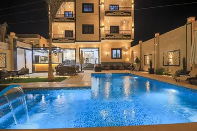 a large swimming pool in front of a building at night at Elbakry Hotel Luxor in Luxor