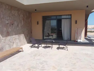 a patio with chairs and a table in front of a building at Charment Chalet Somabay in Hurghada