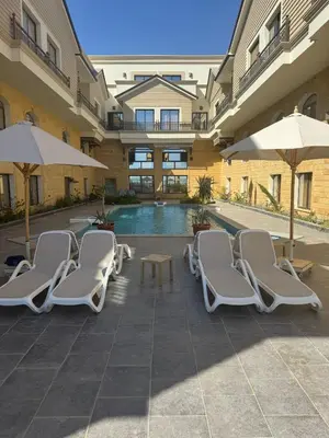 a pool with chairs and umbrellas in a building at 304 aqua blue bay in Hurghada