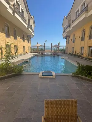 a swimming pool in a courtyard between two buildings at 304 aqua blue bay in Hurghada